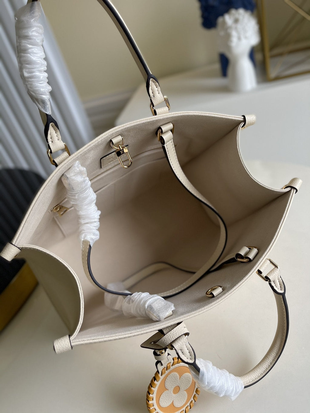 Sac LV Onthego MM 35, garniture en cuir de vachette crème 